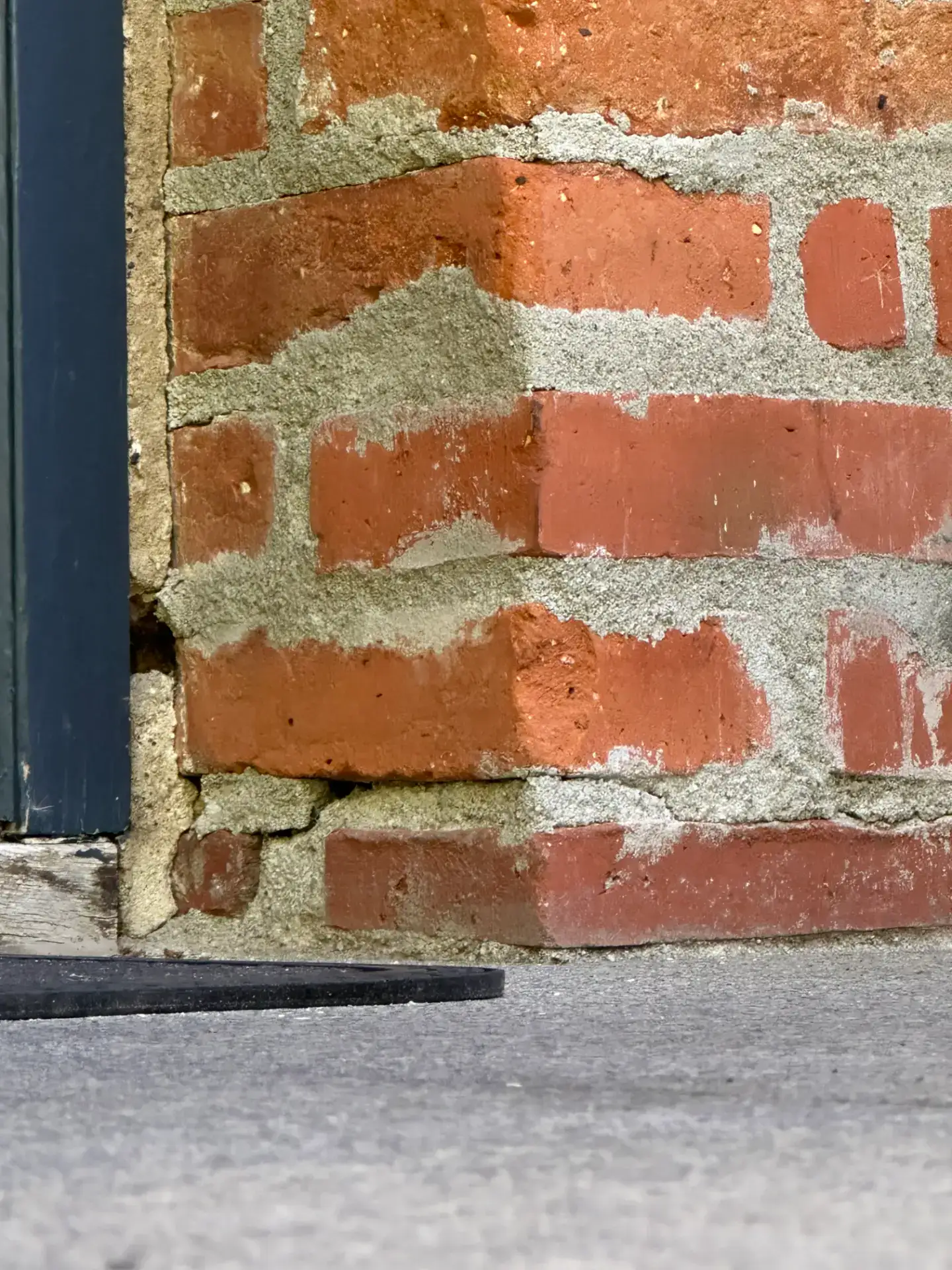 Detalje af murværk med synlige mursten og mørtel.