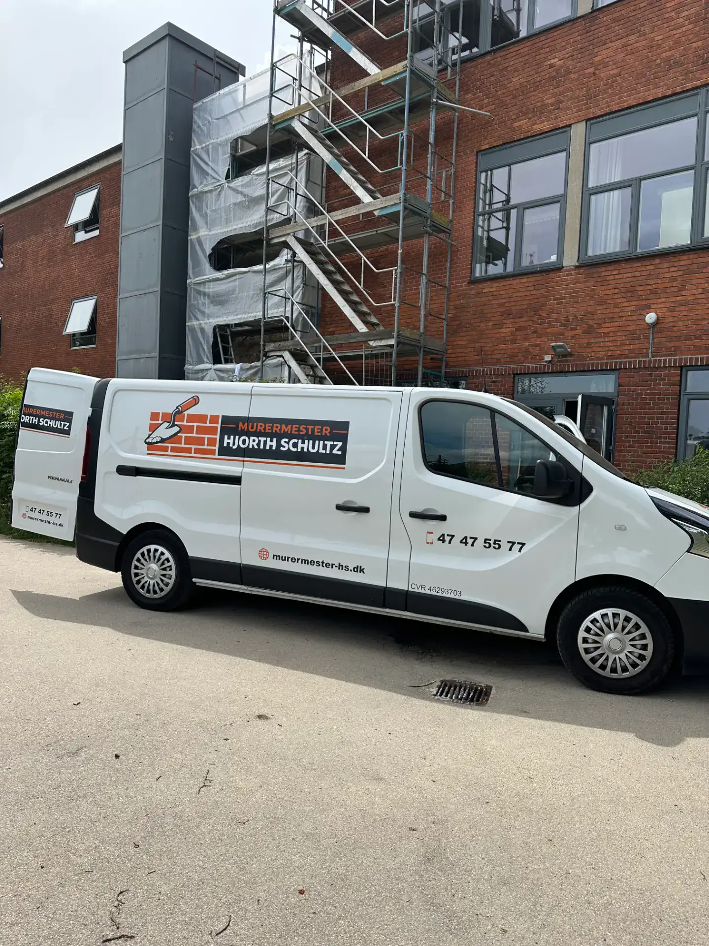 Murermester Hjorth Schultz servicebil foran en bygning under renovering.