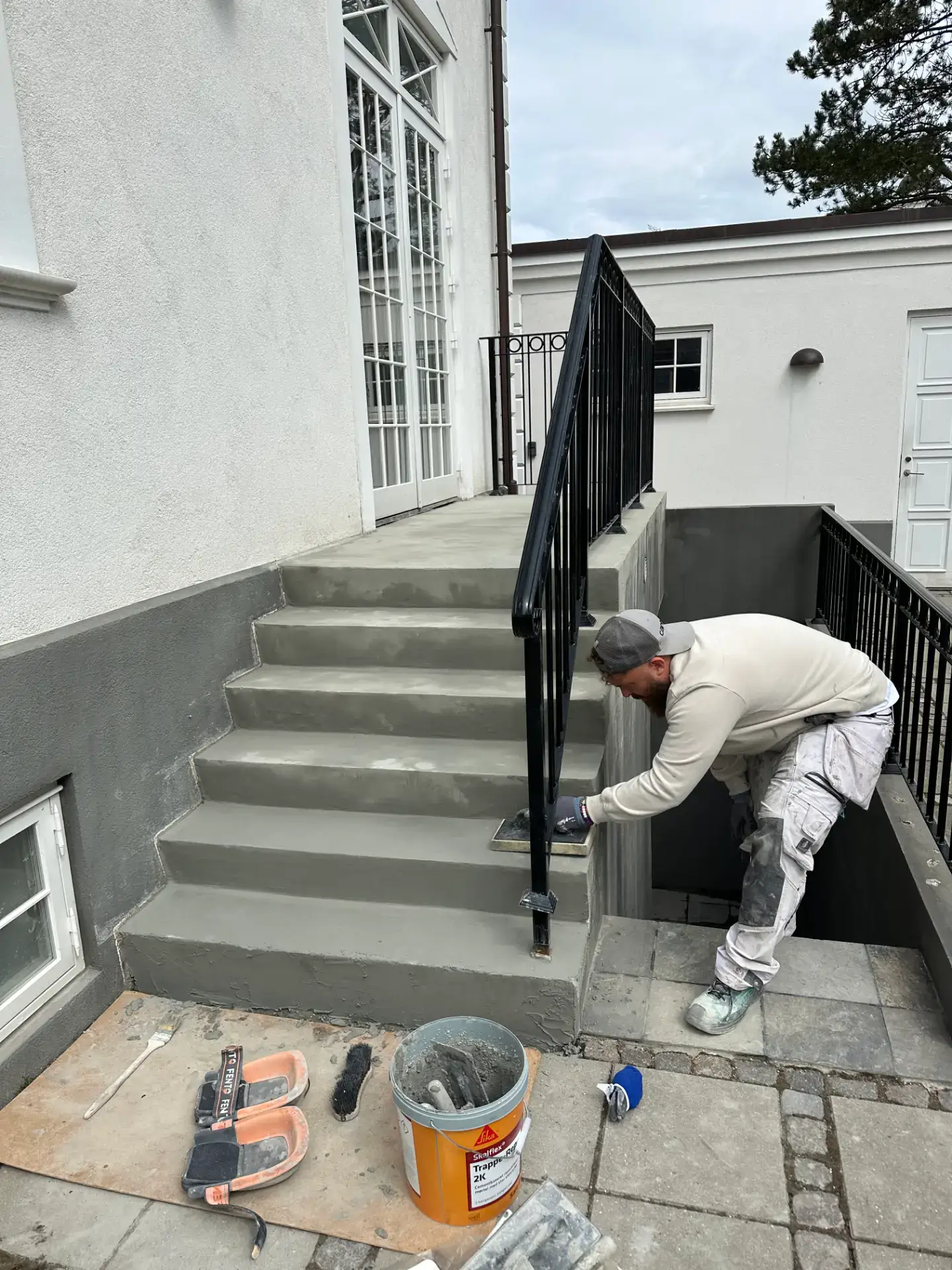 Murer arbejder på trappeudskiftning udenfor huset.